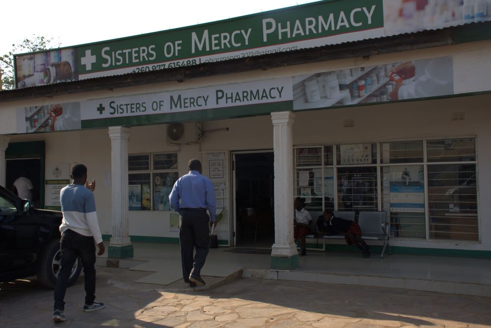 exterior of pharmacy, with two people walking toward door