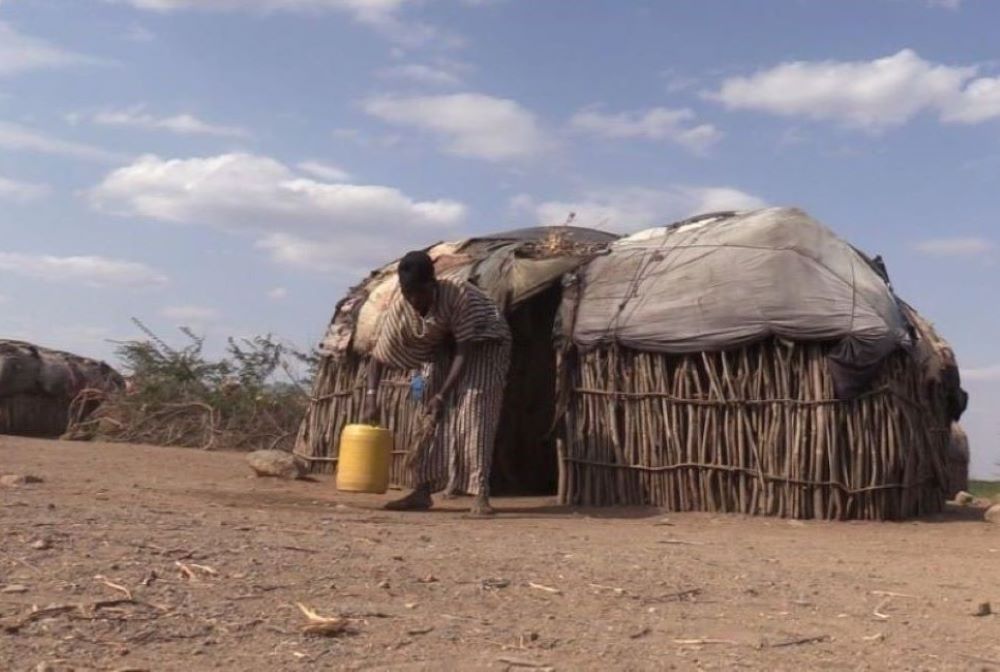Jemima Cheruto bends to fetch water outside her home in Ortum, northern Kenya. 