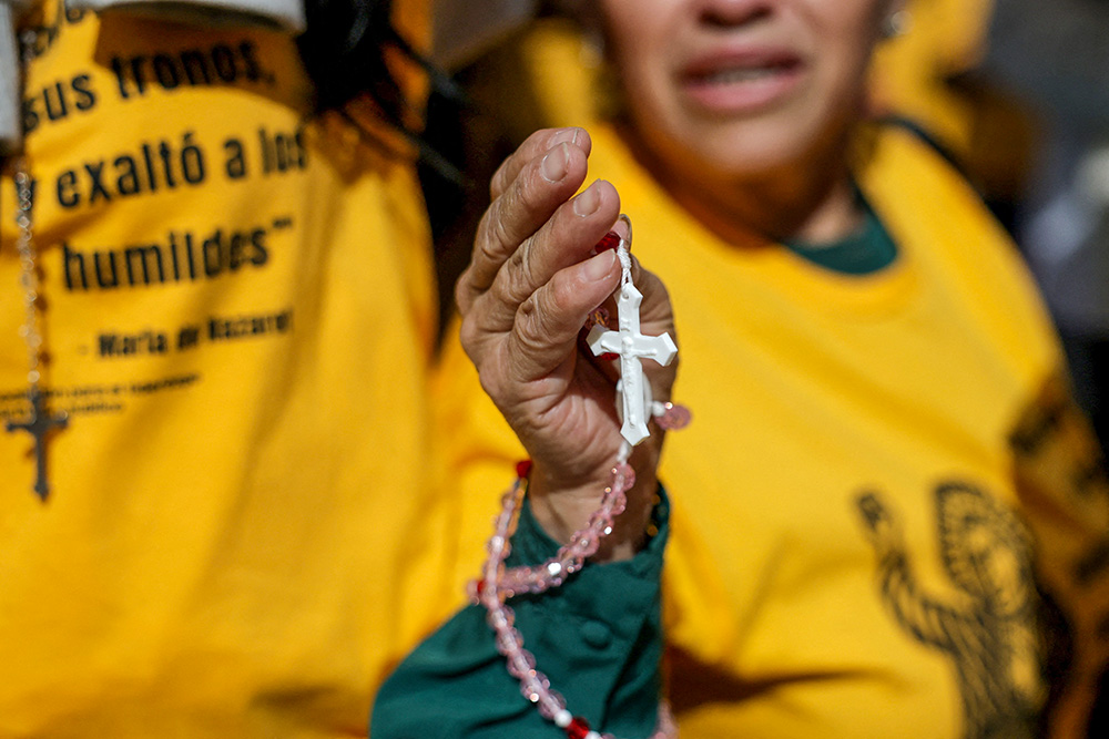A woman holds a rosary as members of a Catholic group take part in a eucharistic procession near the U.S. Immigration and Customs Enforcement (ICE) Broadview facility in Chicago Oct. 11, 2025. (OSV News/Reuters/Jeenah Moon)