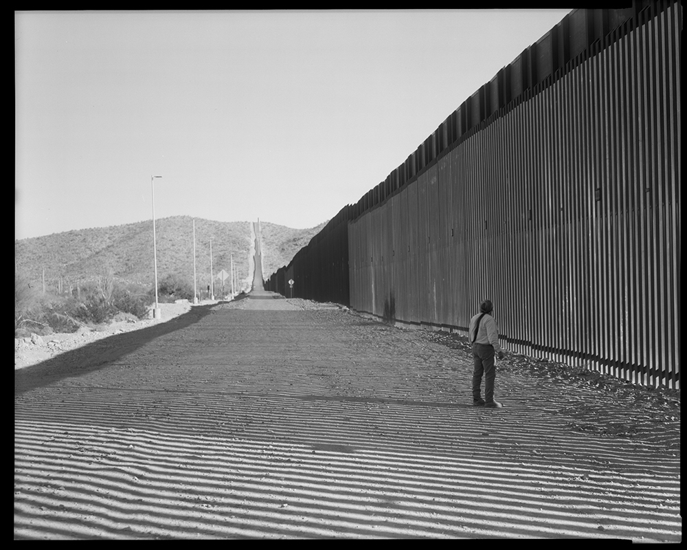 Samuel Fayuant stands before Monument Hill in the Organ Pipe Cactus National Monument, a sacred place where O'odham ancestors have been buried. The wall built during the Donald Trump presidency runs through this sacred ground. (Lisa Elmaleh)