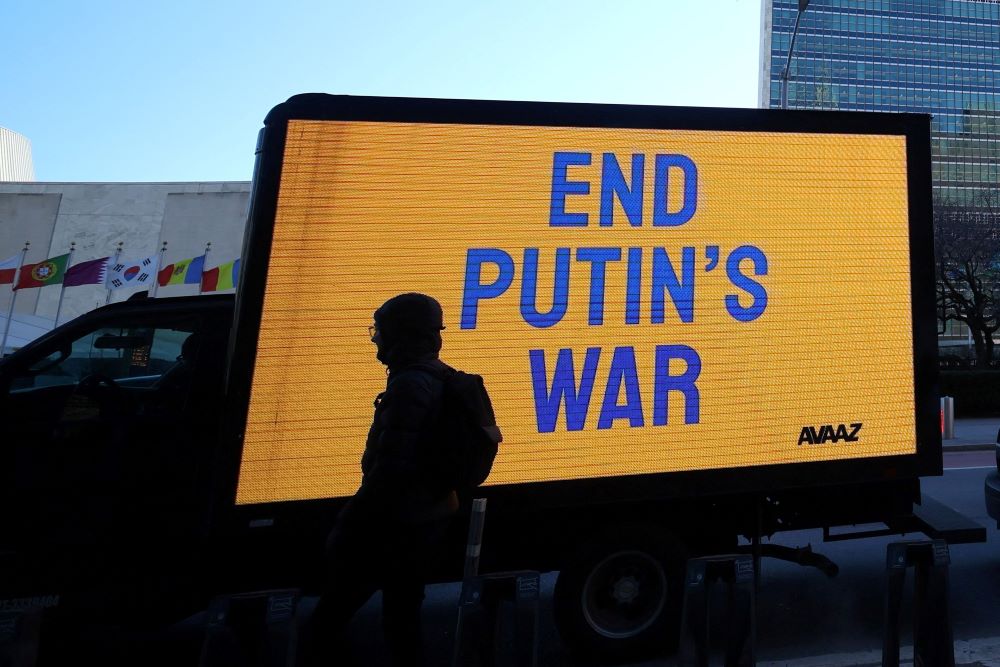 A truck displays an electronic message while protesters demonstrate outside United Nations headquarters in New York City, as diplomats inside hold an emergency session of the 193-member U.N. General Assembly. (CNS/Reuters/Mike Segar)