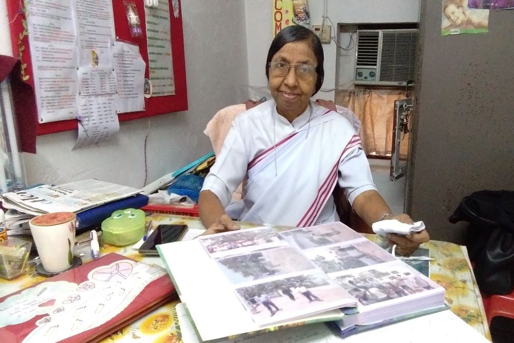 Sr. Judith Meckado of the Franciscan Missionaries of Christ the King displays a photo album with pictures of "A Pilgrimage of the Heart" at her office in Old Goa, western India. (Lissy Maruthanakuzhy)