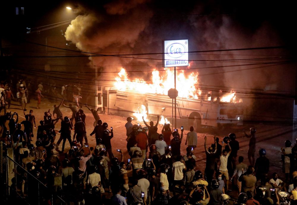 Demonstrators react after they set a fire to a bus parked at the top the road to Sri Lankan President Gotabaya Rajapaksa's residence during a protest in Colombo March 31. (CNS/Reuters/Dinuka Liyanawatte)