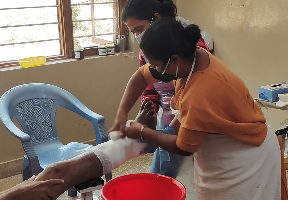 Sr. Fathima Mary Lourdraj bandages a patient at Sumanahalli's clinic in Bengaluru, India. The main charism of her order, the Franciscan Sisters of the Immaculate, is to serve those afflicted with leprosy. (Thomas Scaria)