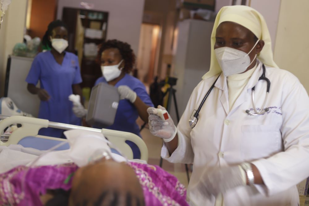 Sr. Assumpta Nabawanuka attends to a patient at St. Francis Hospital Nsambya in Kampala, Uganda's capital.