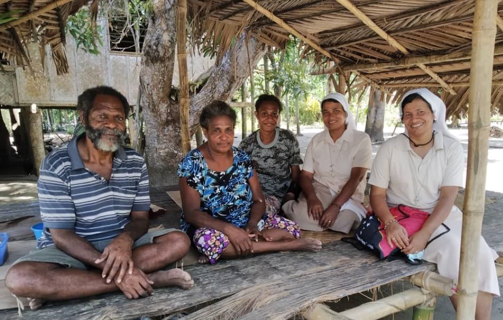 Sr. Shephali Khalko of the Missionary Sisters of the Immaculate, second from right, conducts a family visit with another nun in Gulf Province in Papua New Guinea. She has been working in the country for 10 years. (Courtesy of Shephali Khalko)