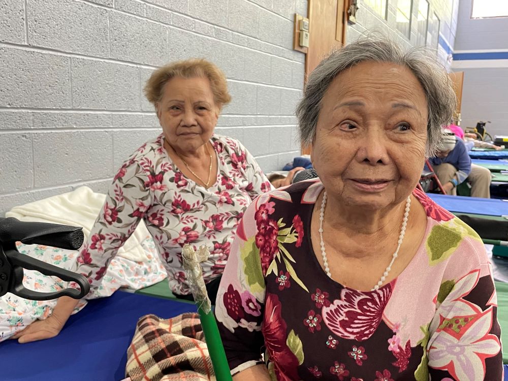 Pham This Sang, 91, and her sister, Pham This Menh, 81, were resting in the air conditioned large hall for elderly people. Small beds were set up for people to rest. (Peter Tran)