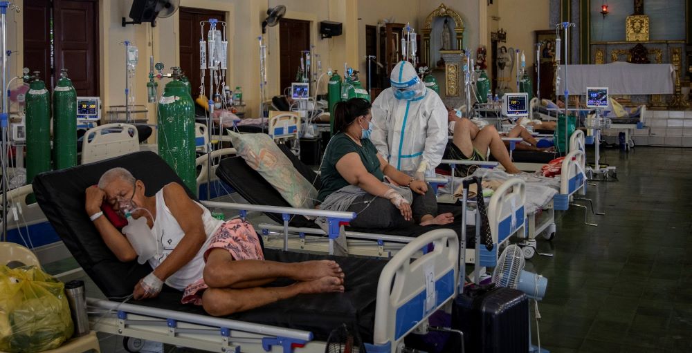 A health worker tends to a coronavirus patient Aug. 20 in the chapel of Quezon City General Hospital, which was turned into a COVID-19 ward amid rising delta variant infections in the Philippines. (CNS/Reuters/Eloisa Lopez)