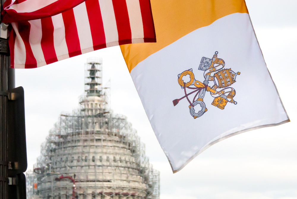 US flag, Vatican flag seen with US capitol dome in background with scaffolding