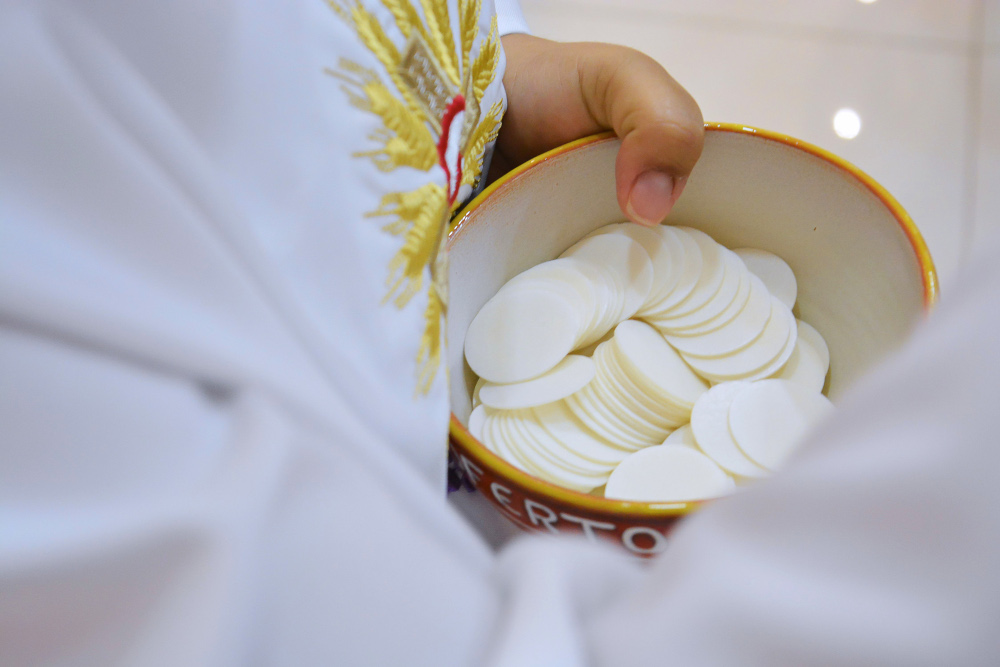 A priest offers Holy Communion. (Wikimedia Creative Commons/Lininha_bs)