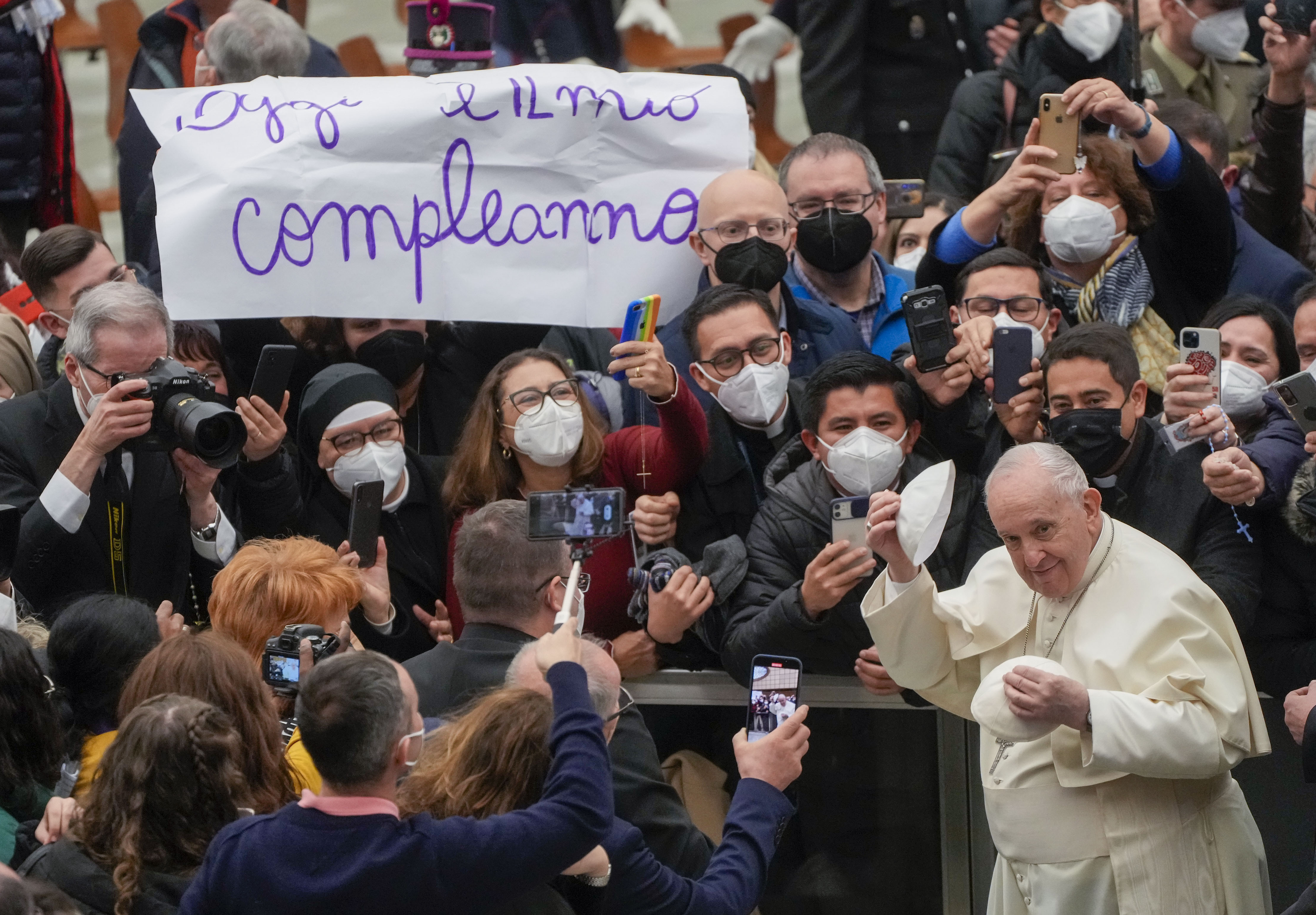 Pope Francis puts on a skull cap he was just presented with as he walks by a placard in Italian reading : "Today is my birthday", at the end of his weekly general audience in the Paul VI Hall at the Vatican, Wednesday, Feb. 02, 2022. (AP Photo/Gregorio Bo Pope Francis puts on a skull cap he was just presented with as he walks by a placard in Italian reading : "Today is my birthday", at the end of his weekly general audience in the Paul VI Hall at the Vatican, Wednesday, Feb. 02, 2022. (AP Photo/Gregorio Bo