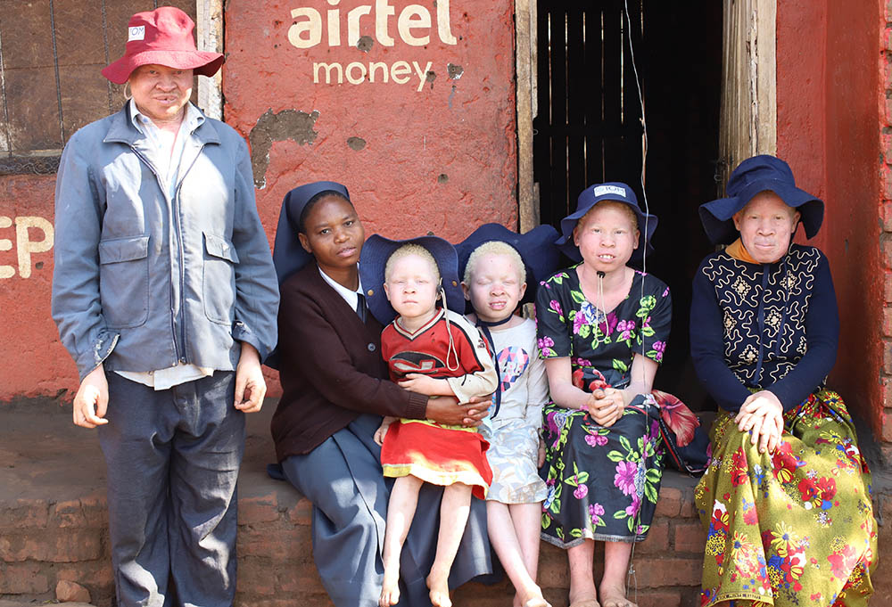 Sr. Beatrice Mbilima of the Teresian Sisters (second from left) visits Loness Masautso's family in Mtendere, a large village some 60 miles south of the Malawian capital of Lilongwe.