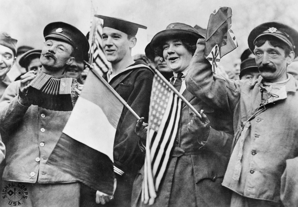 An American sailor, an American Red Cross nurse and two British soldiers celebrate the signing of the Armistice, near the Paris Gate at Vincennes, France, Nov. 11, 1918. (Wikimedia Commons/Imperial War Museum)