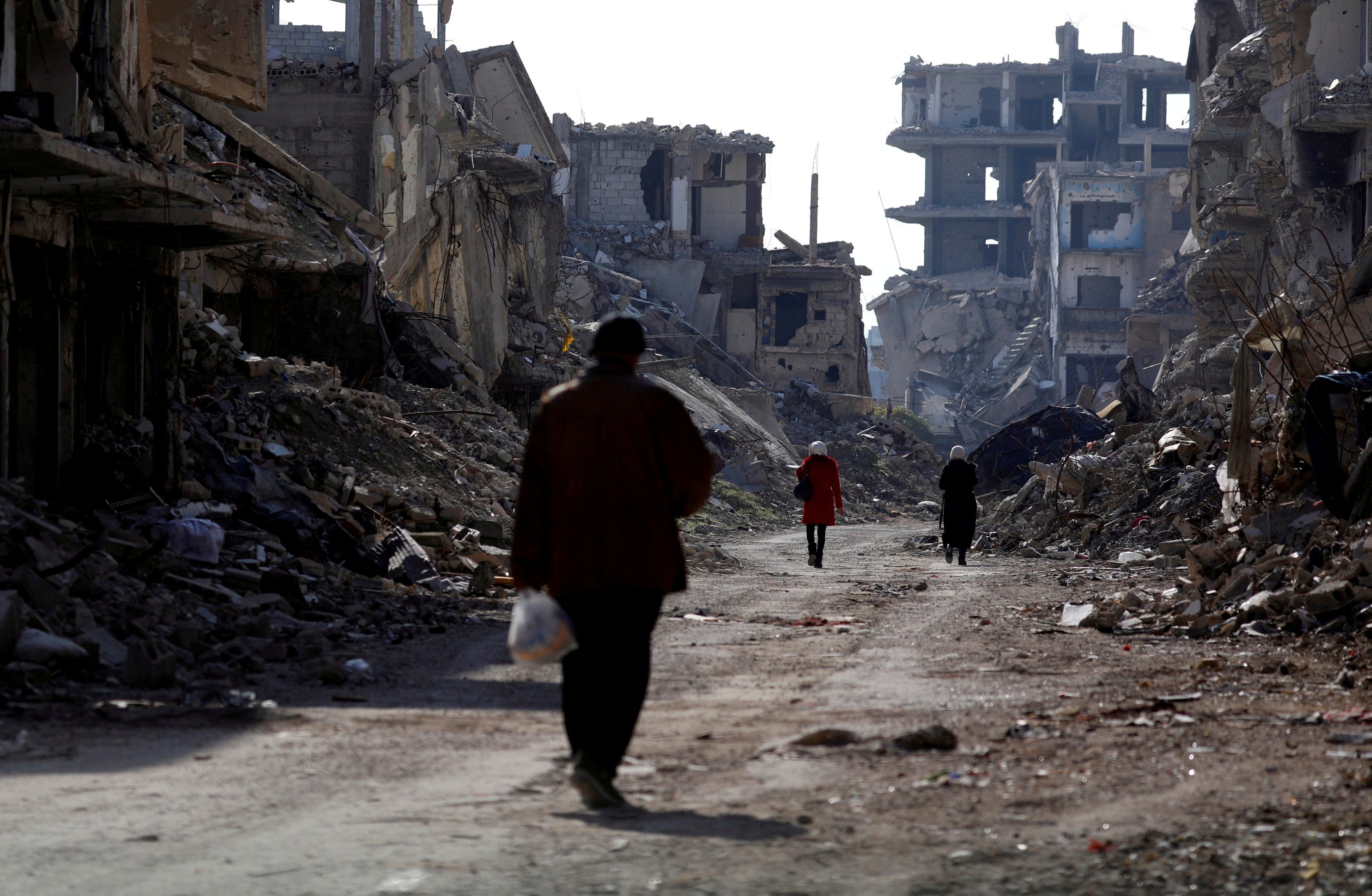 People walk past damaged buildings at the Yarmouk Palestinian refugee camp on the outskirts of Damascus, Syria Dec. 2, 2020.(CNS/Reuters/Omar Sanadiki) People walk past damaged buildings at the Yarmouk Palestinian refugee camp on the outskirts of Damascus, Syria Dec. 2, 2020.(CNS/Reuters/Omar Sanadiki)