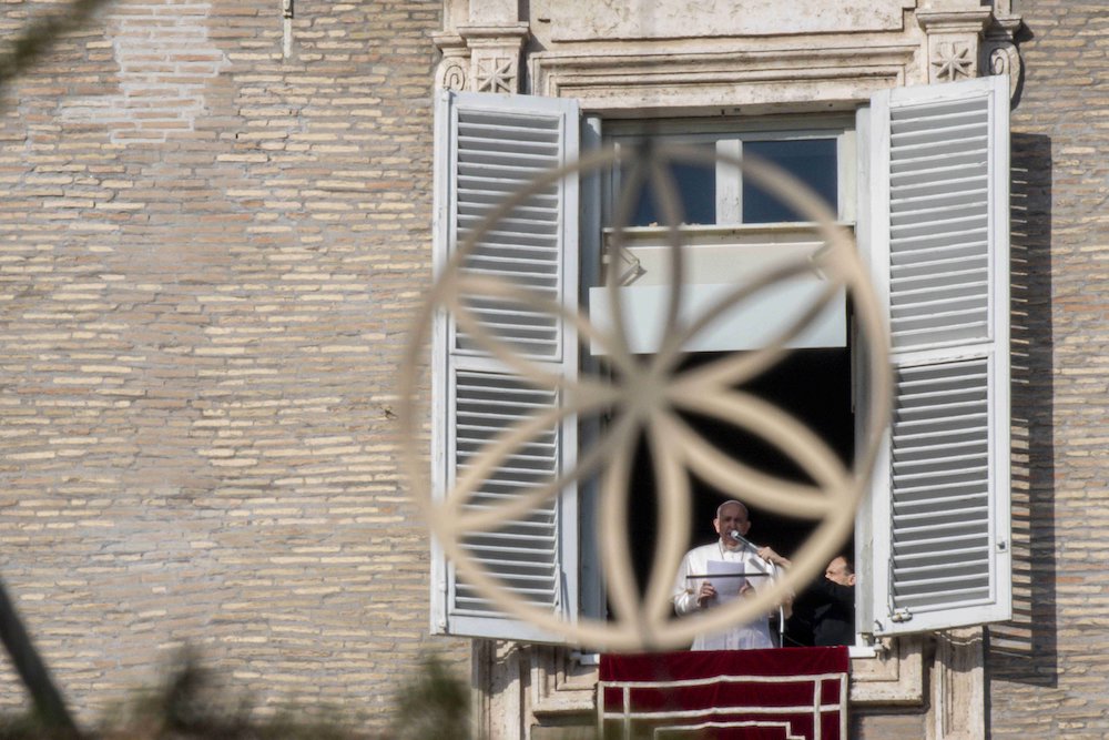 Pope Francis is pictured through an ornament on the Christmas tree as he leads the Angelus from the window of his studio overlooking St. Peter's Square at the Vatican Dec. 20. (CNS/Vatican Media)