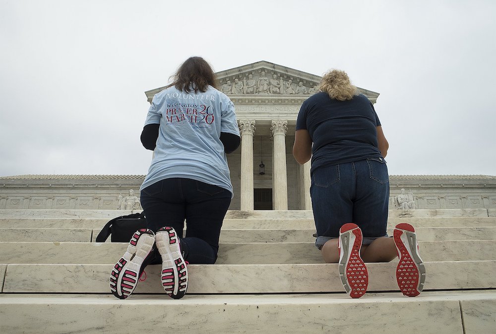 People pray outside the U.S. Supreme Court in Washington Sept. 26. (CNS/Tyler Orsburn)