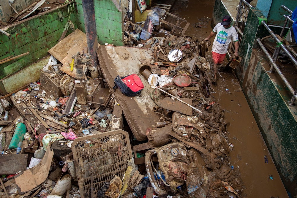 A person cleans up flood damage Jan. 3, following heavy rains in Jakarta, Indonesia. (CNS/Reuters/Antara Foto/Dhemas Reviyanto)