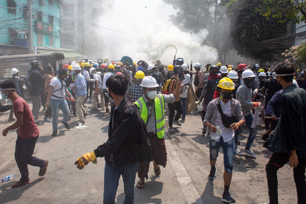 Protesters retreat after police opened fire to disperse an anti-coup protest in Mandalay, Myanmar, March 3, 2021.