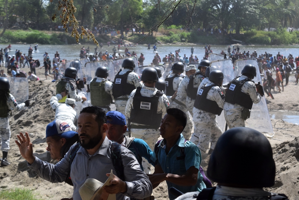 Members of Mexico's National Guard hold their shields to block migrants in Ciudad Hidalgo, part of a caravan traveling to the United States near the border between Guatemala and Mexico in January. Hundreds of Central American migrants waded across the Suc