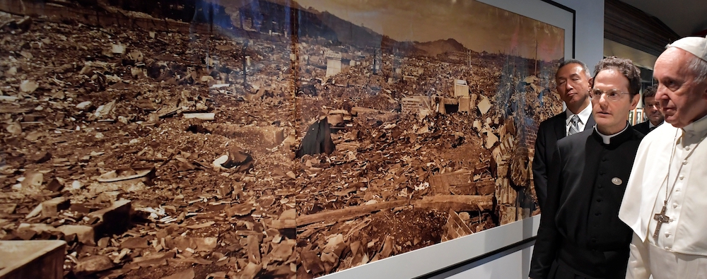 Pope Francis looks at a photo showing the destruction of an atomic bomb during a visit to the Jesuit-run Sophia University in Tokyo Nov. 26, 2019. (CNS/Vatican Media via Reuters)