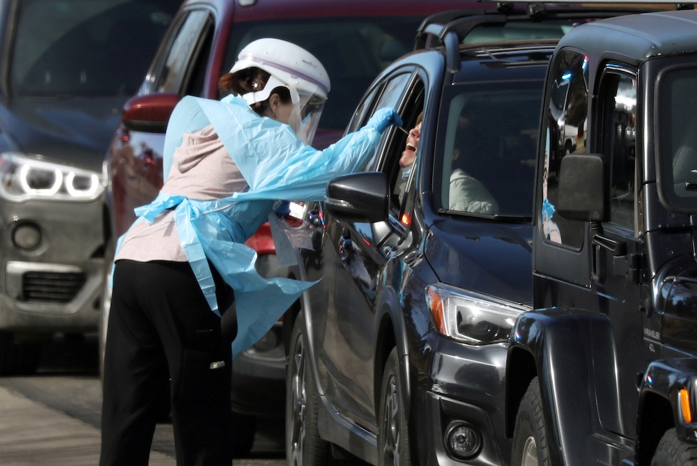 COVID 19 testing Colorado A health care worker in Denver tests people for the coronavirus at a drive-thru testing station March 11, 2020. (CNS/Reuters/Jim Urquhart)
