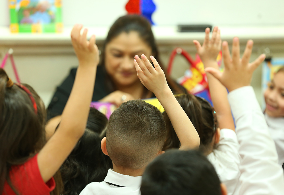 Cristina Escobedo, seen in the background, teaches students at St. Mary Magdalen School in San Antonio. (Jesus Ramirez)