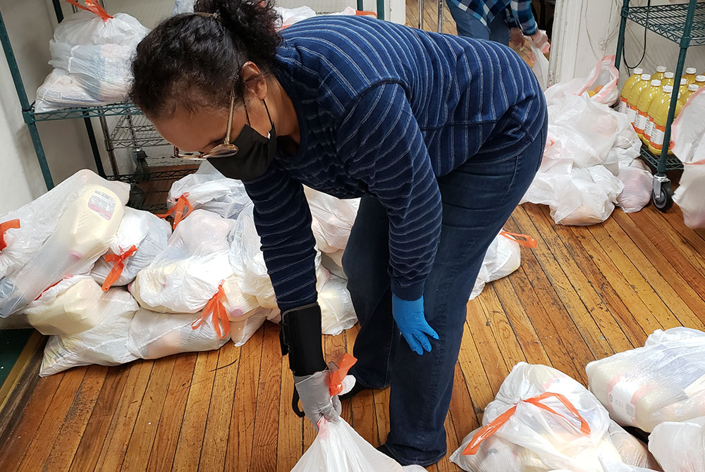 Volunteer Heather Lee organizes food packages to be distributed Oct. 27 at Cabrini Immigrant Services, located in Lower East Side, Manhattan, New York City. (GSR photo/Chris Herlinger)