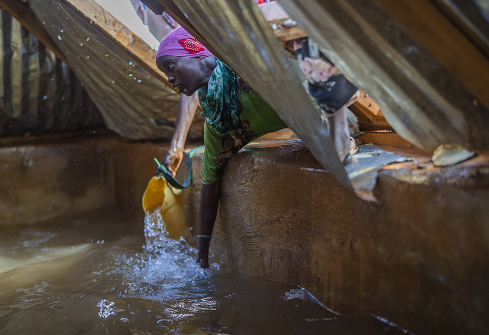 A Somali woman fills a container with water Sept. 20 at a camp for displaced people on the outskirts of Dollow, Somalia. (AP photo/Jerome Delay)