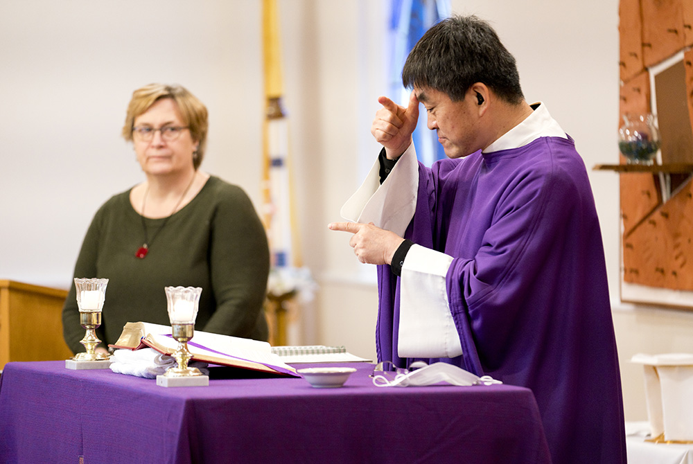 Fr. Min Seo Park signs the Mass in American Sign Language on Ash Wednesday, Feb. 17, 2021. To his left is Laureen Lynch-Ryan, the Washington Archdiocese's coordinator for deaf ministry. (Joe Portolano) Fr. Min Seo Park signs the Mass in American Sign Language on Ash Wednesday, Feb. 17, 2021. To his left is Laureen Lynch-Ryan, the Washington Archdiocese's coordinator for deaf ministry. (Joe Portolano)