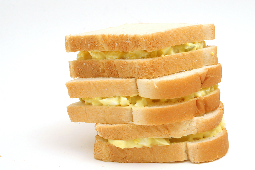 Stack of three egg salad sandwiches on white bread (Dreamstime/Andi Berger)