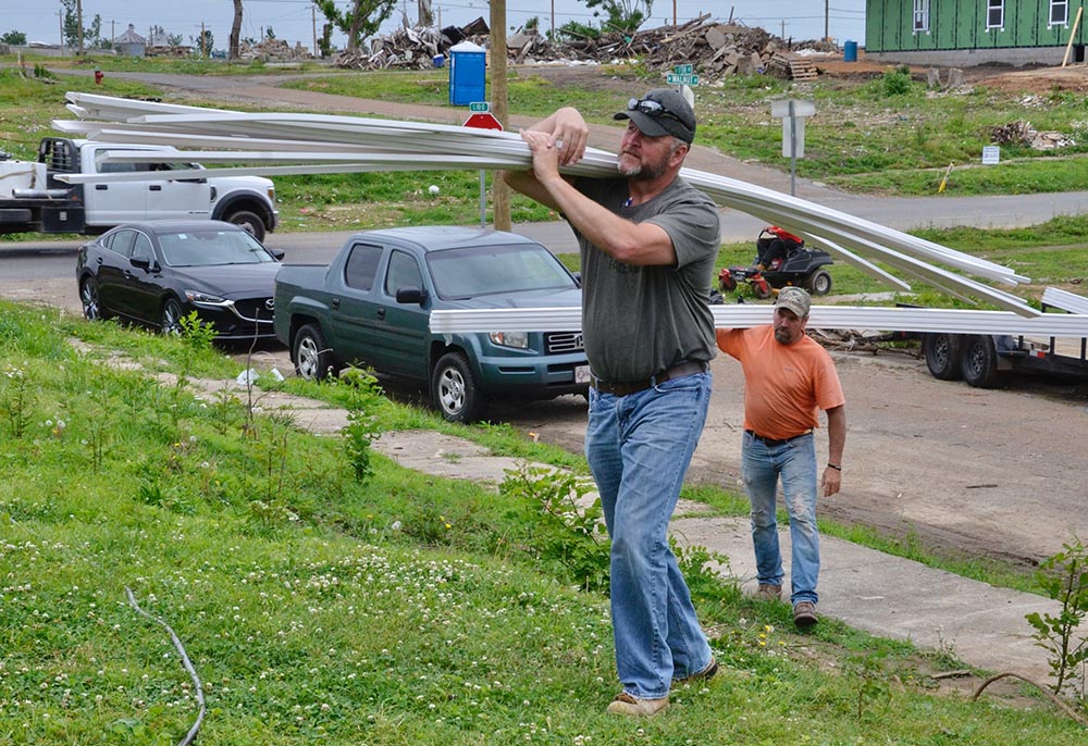 Eric Shelburne, left, and Ronnie Mattingly carry trim to a house where the Sisters of Charity of Nazareth's disaster recovery team is helping a family rebuild May 23 after a devastating tornado in Mayfield, Kentucky. (GSR photo/Dan Stockman)