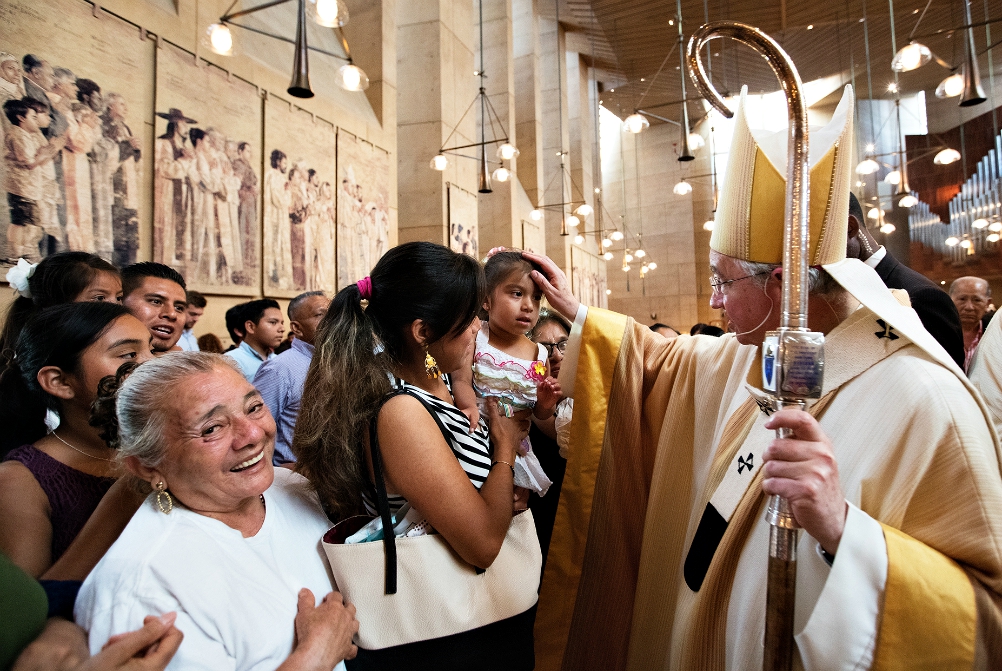 Archbishop José Gomez blesses a girl during a special Mass celebrated in recognition of all immigrants at the Cathedral of Our Lady of the Angels in Los Angeles in July 2016. (CNS/Vida Nueva/Victor Aleman)