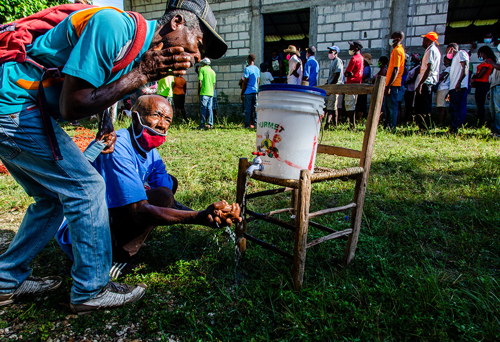 Haitians affected by the August 2021 earthquake in southern Haiti are seen in September at a Catholic Relief Services distribution site in the locality of Kay Raymond, Petit-Trou-de-Nippes, Haiti. (Catholic Relief Services/Georges Harry Rouzier)