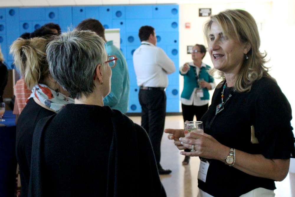 Dima Khoury, Miller Center mentor, talks with attendees at the San Francisco Bay Area GSBI Boost final presentation July 26. (Heather Adams)