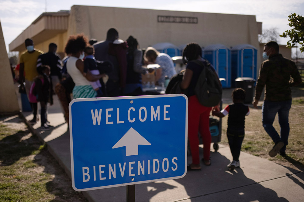 Migrants from Haiti wash clothes as they arrive March 21 at the Val Verde Border Humanitarian Coalition after being released from U.S. Customs and Border Protection in Del Rio, Texas. (CNS/Reuters/Adrees Latif)