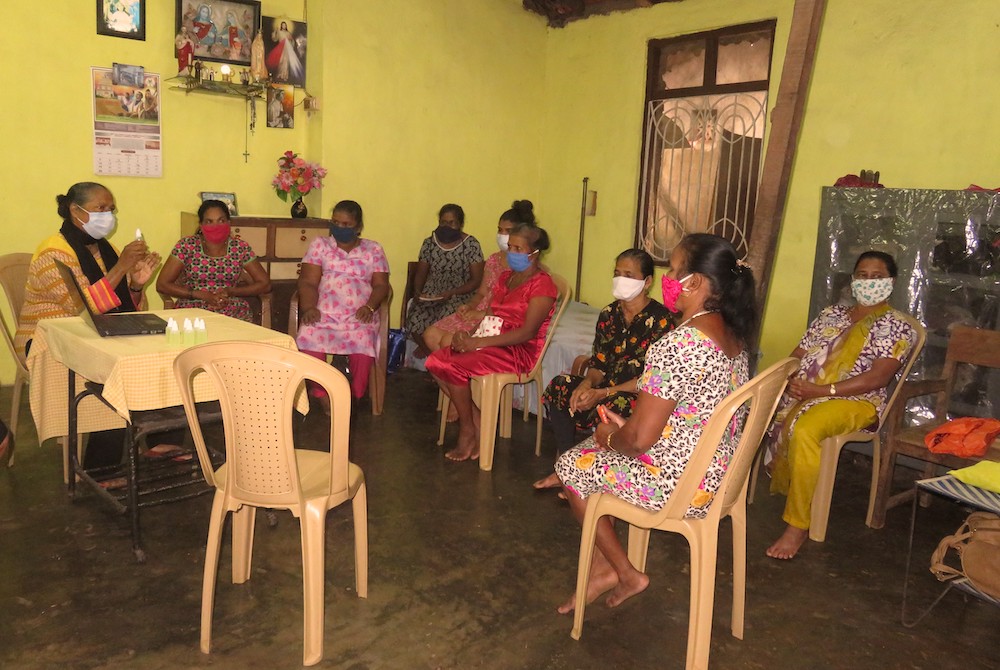 Sr. Marie Lou Barboza, left, discusses the coronavirus at an awareness training program for local and migrant workers at Calangute, Goa, India. (Provided photo)