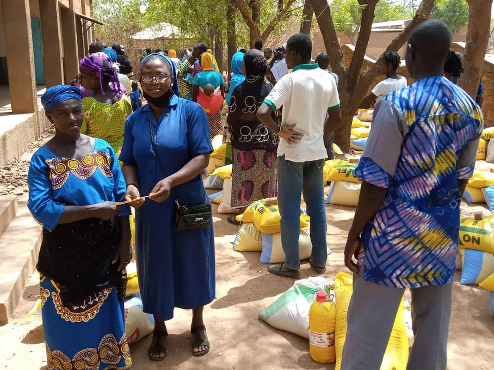 Sr. Ojonoka Acheneje, a Daughter of Charity of St. Vincent De Paul, distributes food to internally displaced persons in the Diocese of Nouna, Burkina Faso. (Courtesy of Janet E. Deinanaghan)