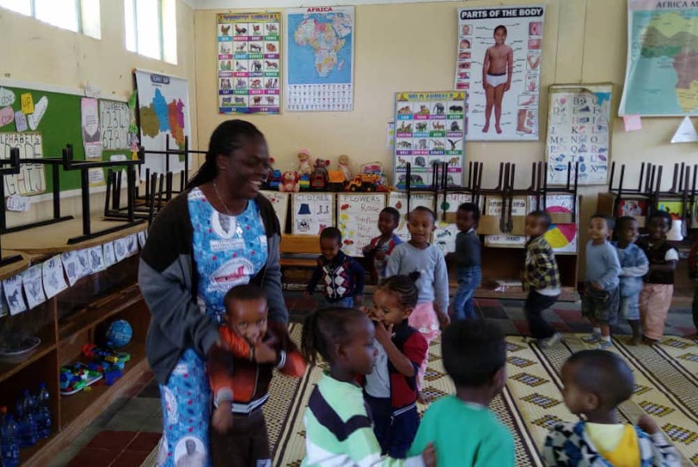 Woman in a Kindergarten room surrounded by children