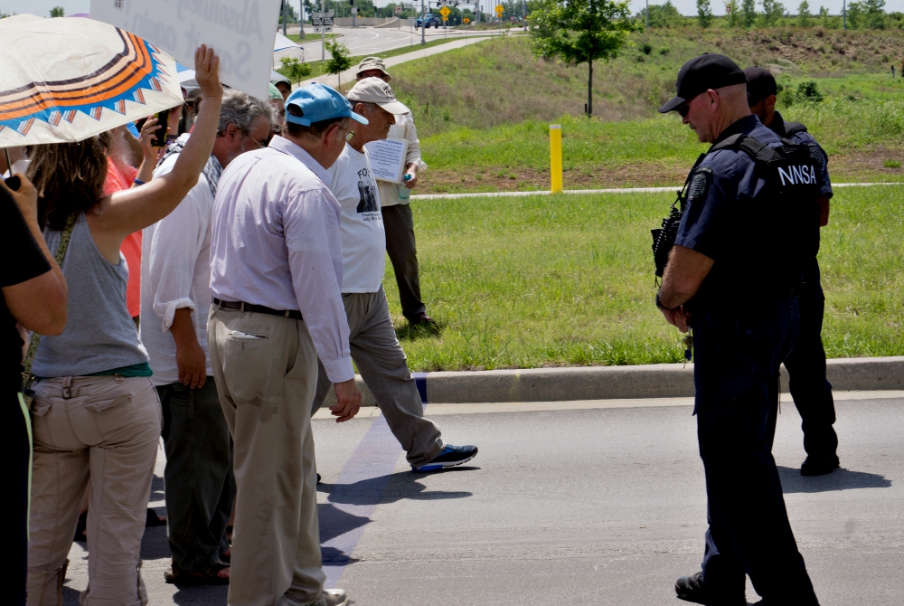 Tom Fox steps over a purple line painted on a road leading to the Kansas City National Security Campus on Memorial Day, May 28, in Kansas City, Missouri. (Jeff Davis)