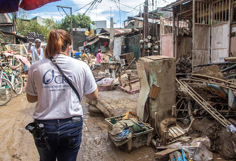 A Catholic Relief Services official walks through the aftermath of Typhoon Vamco, known locally as Ulysses, which made landfall on the Philippines on Nov. 11, 2020. Its destructive winds and intense rains triggered extensive flooding in several areas.