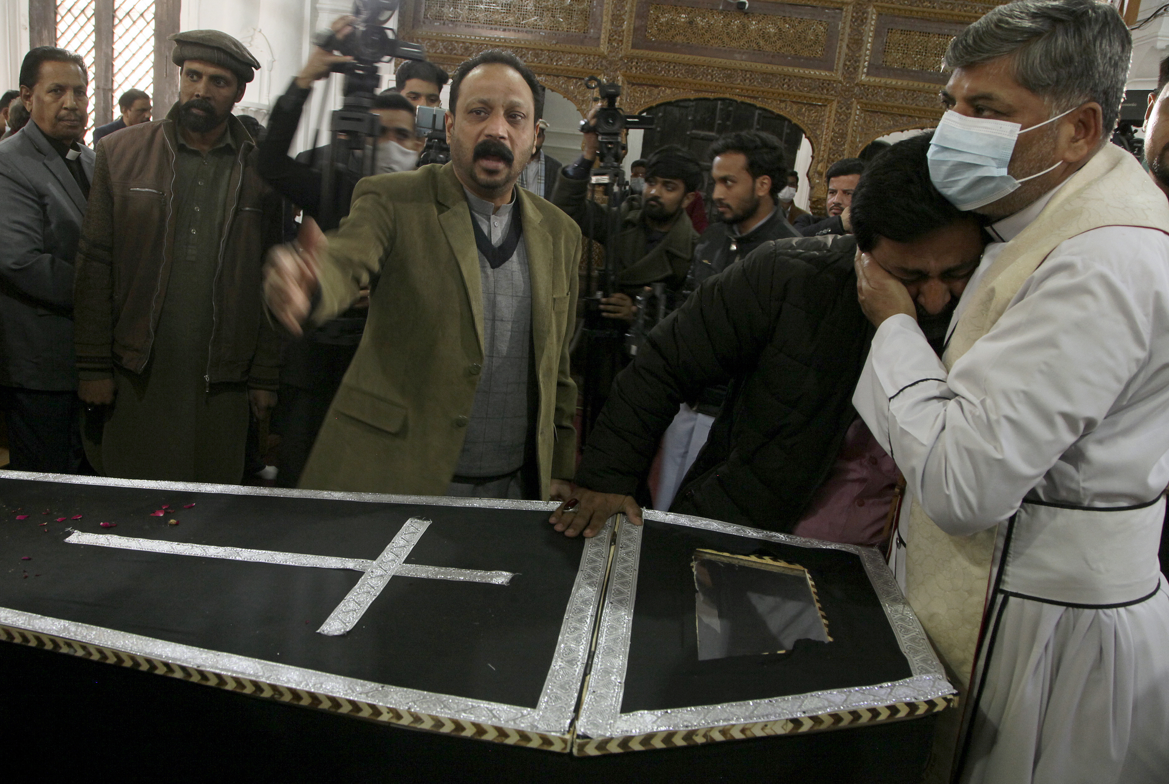 A clergyman comforts a relative of Christian priest Father William Siraj, 75, who was killed by gunmen, during his funeral service at the All-Saints Church, in Peshawar, Pakistan, Jan. 31, 2022. (AP Photo/Muhammad Sajjad) A clergyman comforts a relative of Christian priest Father William Siraj, 75, who was killed by gunmen, during his funeral service at the All-Saints Church, in Peshawar, Pakistan, Jan. 31, 2022. (AP Photo/Muhammad Sajjad)