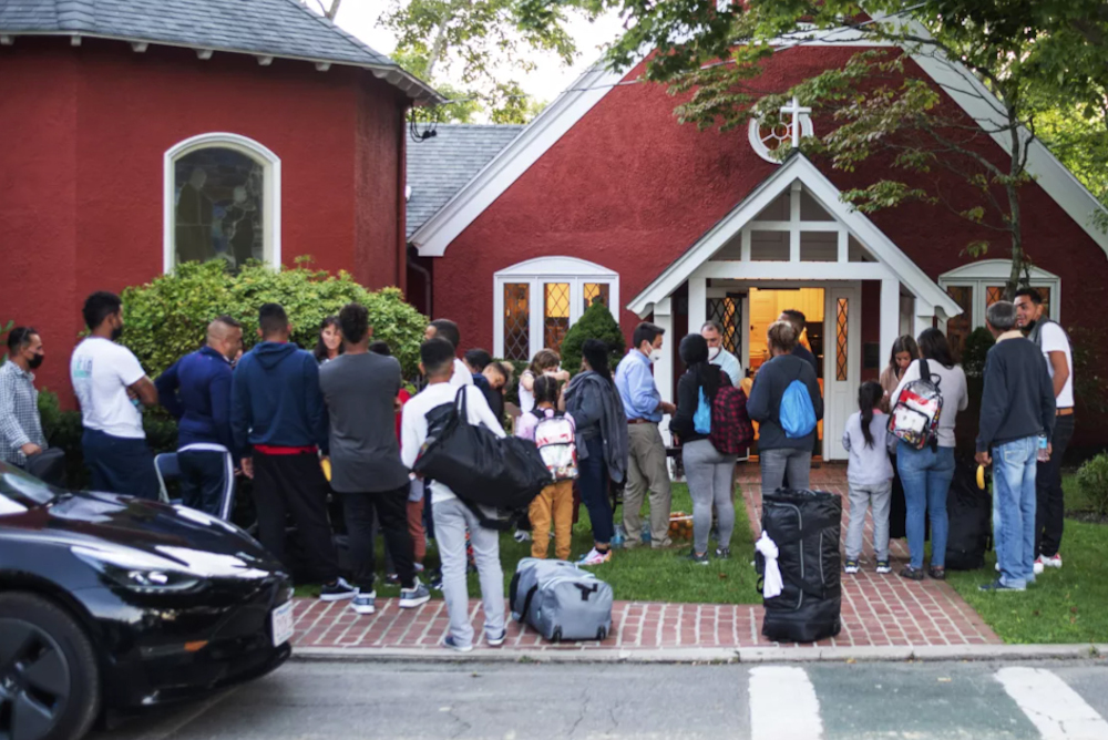 Immigrants gather with their belongings outside St. Andrew's Episcopal Church, Sept. 14, in Edgartown, Massachusetts, on Martha's Vineyard. (Vineyard Gazette via AP/Ray Ewing)