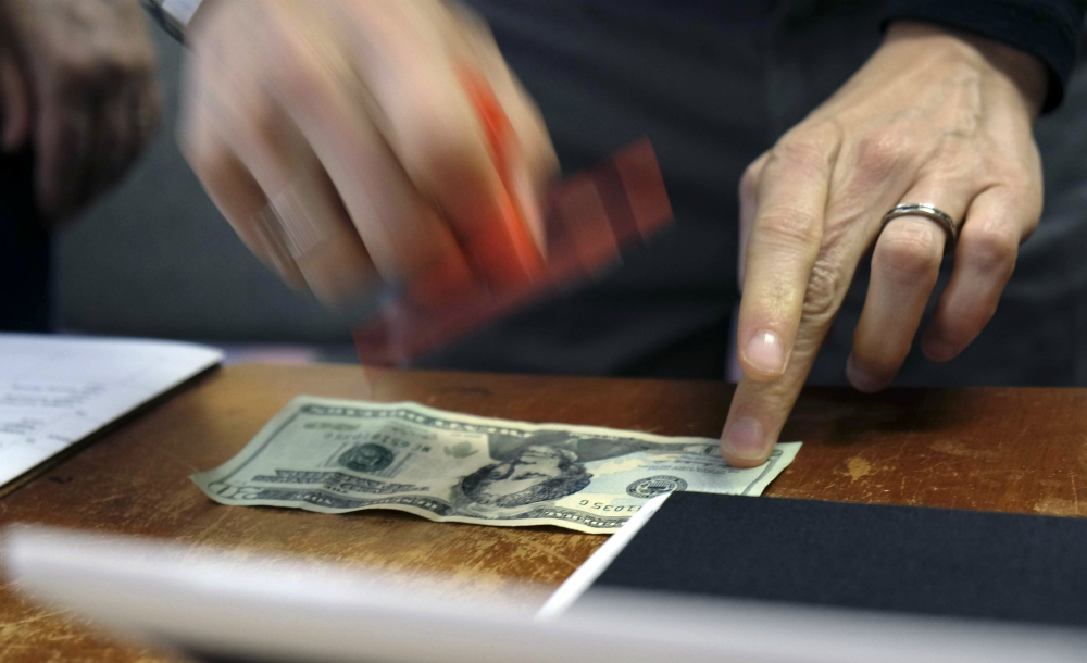 A U.S. $20 bill is stamped with the face of abolitionist Harriet Tubman at Hope Central Church in Boston June 2. (RNS/Aysha Khan)