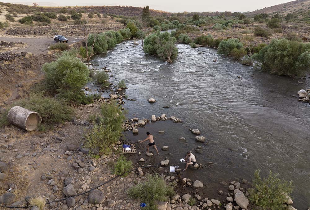 People bathe in the Jordan River near Kibbutz Karkom in northern Israel on July 30. (AP/Oded Balilty)