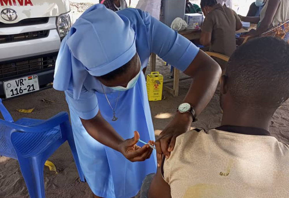 Sr. Seraphine Agorti, a member of the Sisters of Mary Mother of the Church, administers the COVID-19 vaccine to a beneficiary who accepted to be vaccinated after they convinced him through education. (Damian Avevor)