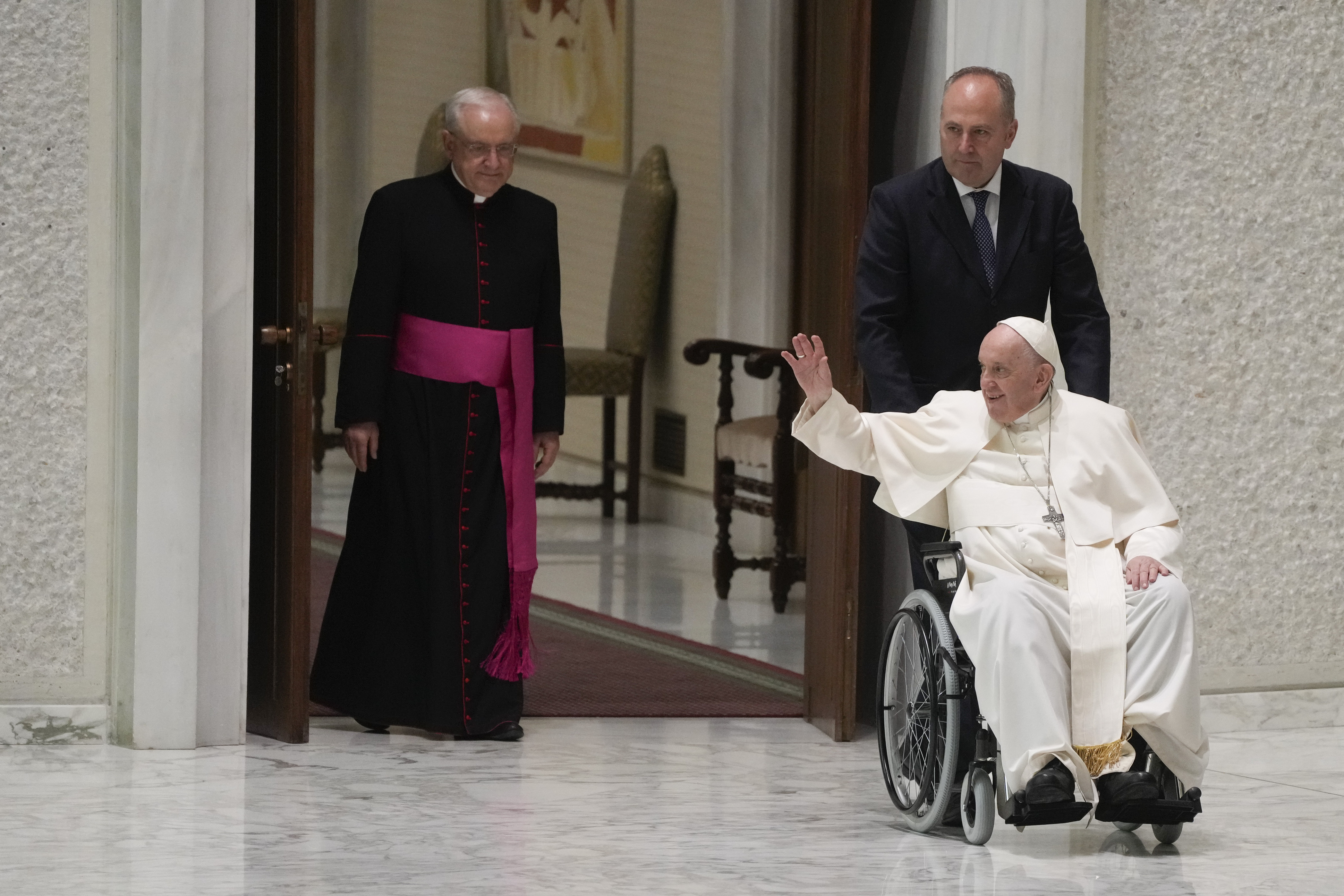 Pope Francis arrives in a wheel chair in the Paul VI hall to attend an audience with pilgrims from central Italy at the Vatican, Saturday, May 14, 2022. (AP Photo/Gregorio Borgia) Pope Francis arrives in a wheel chair in the Paul VI hall to attend an audience with pilgrims from central Italy at the Vatican, Saturday, May 14, 2022. (AP Photo/Gregorio Borgia)