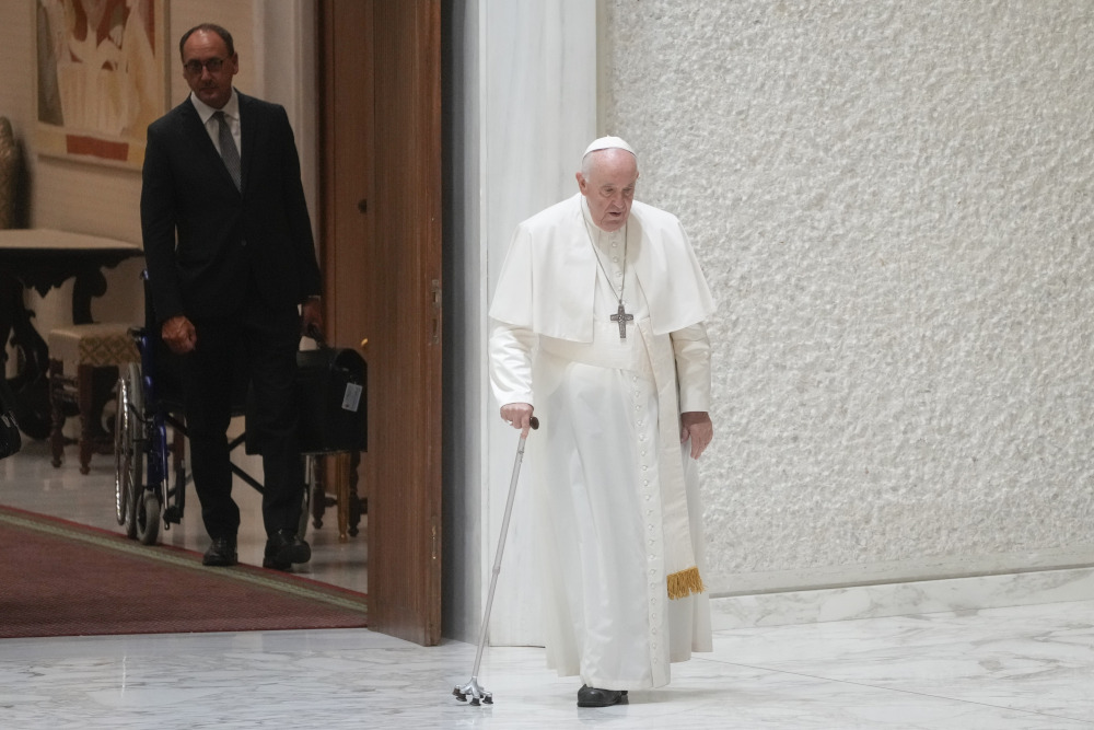 Massimiliano Strappetti, left, watches Pope Francis walking in the Paul VI hall