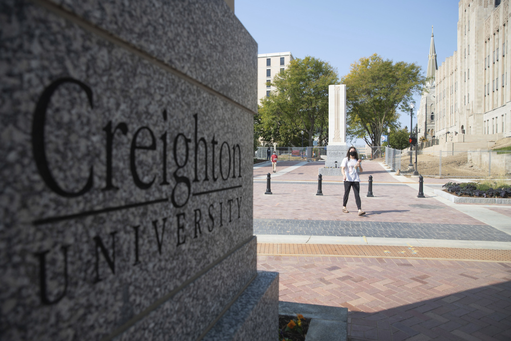 Students walk across 24th Street after the 24th Street dedication and ribbon cutting on the Creighton University campus Sept. 24, 2020, in Omaha, Nebraska.