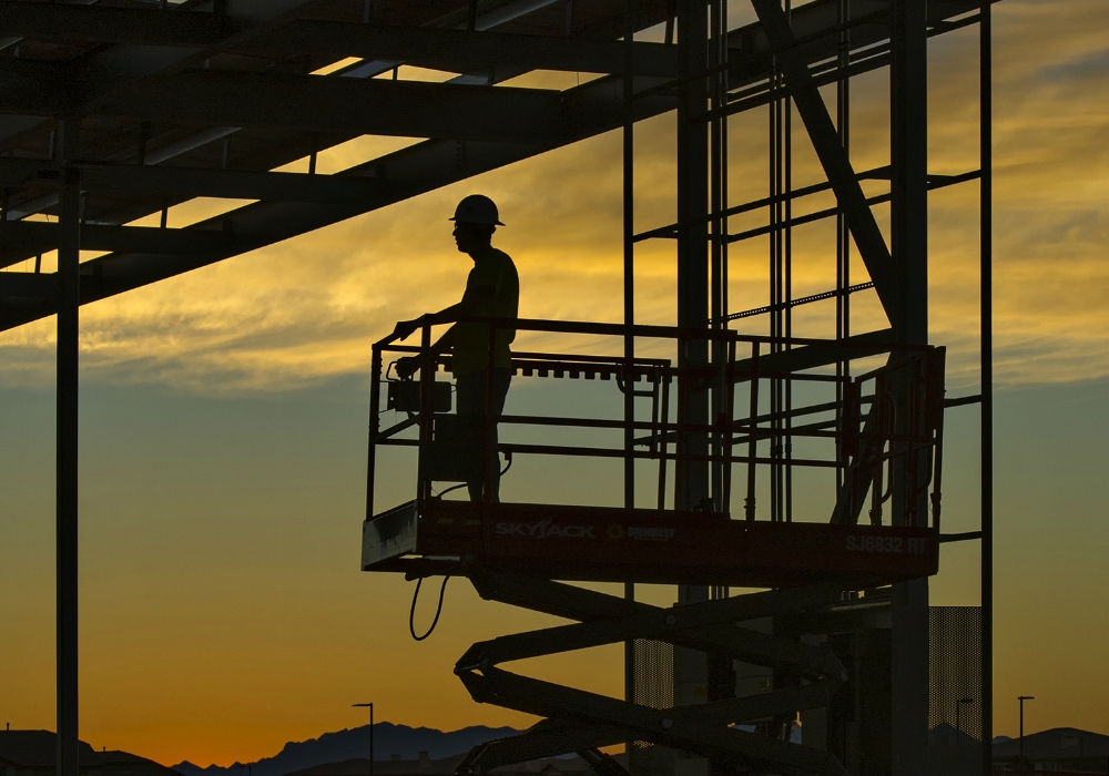 An electrician takes a lift up to 30 feet before sunrise to start string-wiring 2,700 panels on a new solar energy grid in Phoenix in November 2016. (Flickr/U.S. Department of Energy/Michael Nothum)