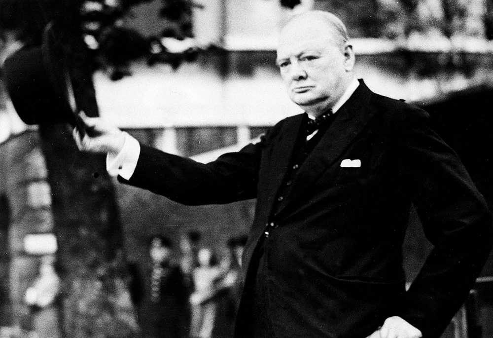 British Prime Minister Winston Churchill doffs his hat as he takes the salute as the Civil Service Home Guard marches by him on review on the Horse Guards Parade, Sept. 17, 1942. (AP photo)